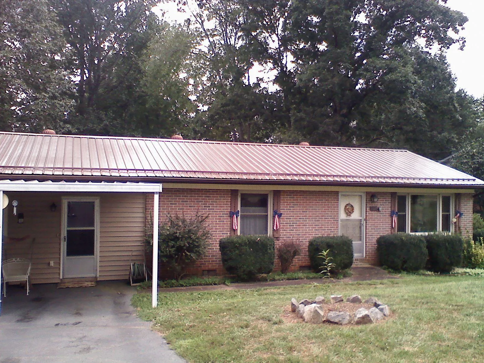 Bronze metal roof and carport on a brick ranch home — Roof Repair work by our crew in Woods Cross