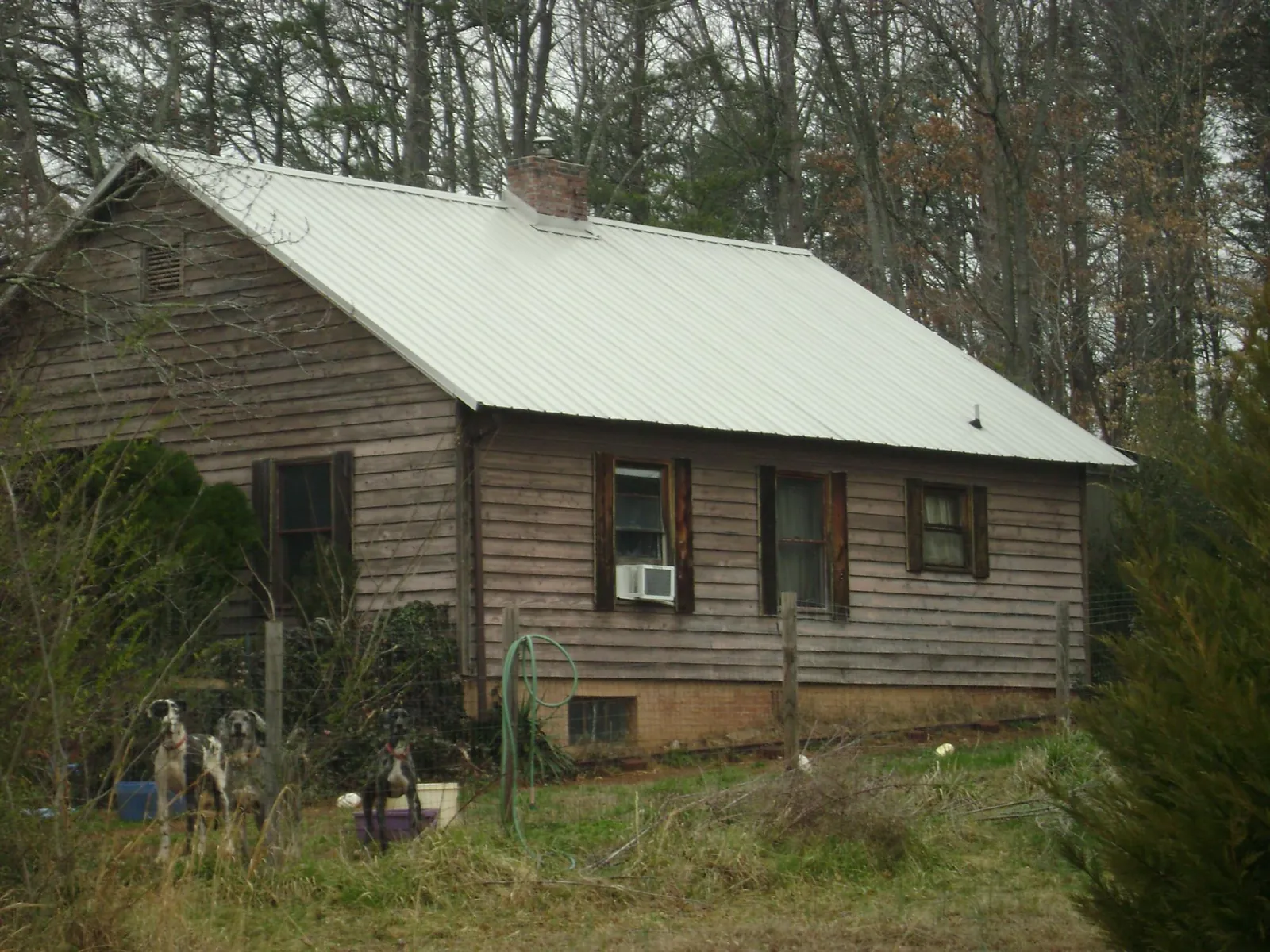 White metal roof on an old wood sided farmhouse, from a Metal Roof Installation job in Woods Cross